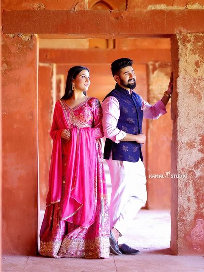 A classic portrait within the red sandstone architecture of the Taj complex, offering a beautiful contrast in color and texture for your pre-wedding photos.