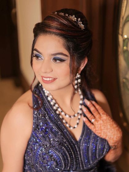 A stunning portrait of the bride from her engagement. Her bold blue eye makeup and elegant pearl necklace are the focus of this shot, showcasing her glamorous and confident style.