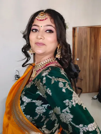 A beautiful look for a Haldi or Mandap ceremony. The makeup is kept fresh and glowing, with pink tones on the eyes and lips to complement the yellow and green saree.