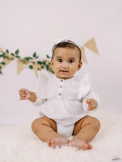 The six-month milestone is full of personality. This little girl's bright, curious eyes and happy expression were captured with a simple, clean setup that lets her shine.