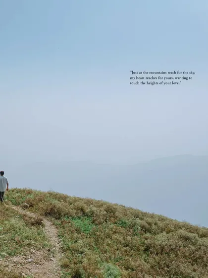 A lone figure walks along a mountain path, a poetic and atmospheric shot from a destination pre-wedding session.