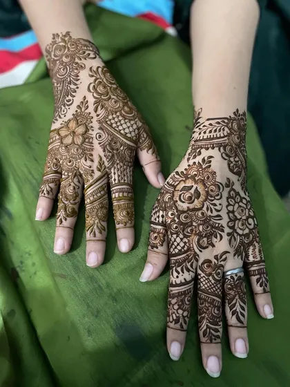 These random pictures show two different hands with complementary floral designs. It's a great option for friends or family who want similar but not identical mehendi.