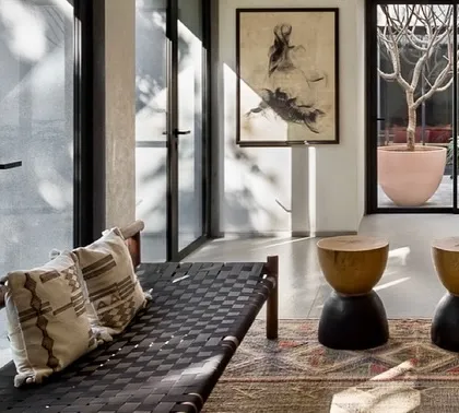 A woven bench sits in a transitional space, looking out onto both a manicured lawn and an internal courtyard. This illustrates how we create multiple connections to the outdoors from different points within the home.