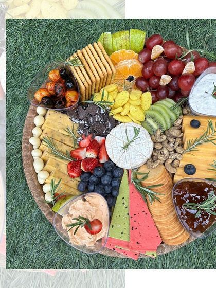 A ready-to-eat cheese and fruit platter, perfect for any occasion. It features a variety of cheeses, crackers, fresh fruits like grapes and berries, and savoury dips.