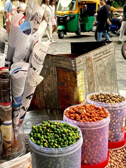 A street vendor's cart with roasted and spiced nuts in newspaper cones, a classic Indian street snack.
