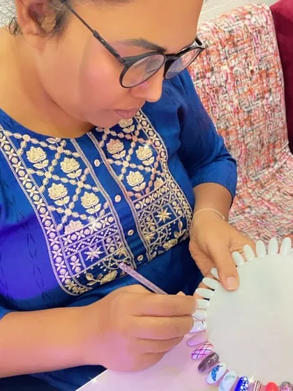 This student is practicing her line work, creating a striped pattern on a practice nail.
