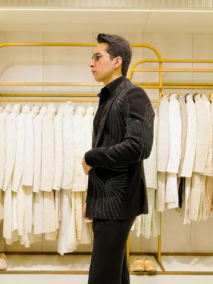The side view of our black beaded blazer shows its clean lines and tailored fit. It's designed to be sharp and modern, perfect for a reception or cocktail party.