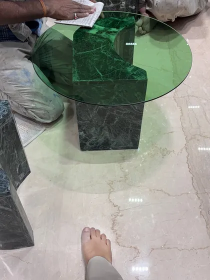Our team polishing the custom green marble coffee table on-site. This level of hands-on craftsmanship ensures a perfect finish.