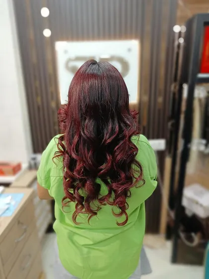 A full head of rich, vibrant red hair styled into beautiful, bouncy curls. This is a statement color that exudes confidence.