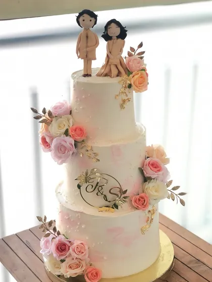 A three-tiered engagement cake for a beautiful new beginning. I designed this piece with delicate blush tones, fresh flowers, and custom fondant toppers of the couple.
