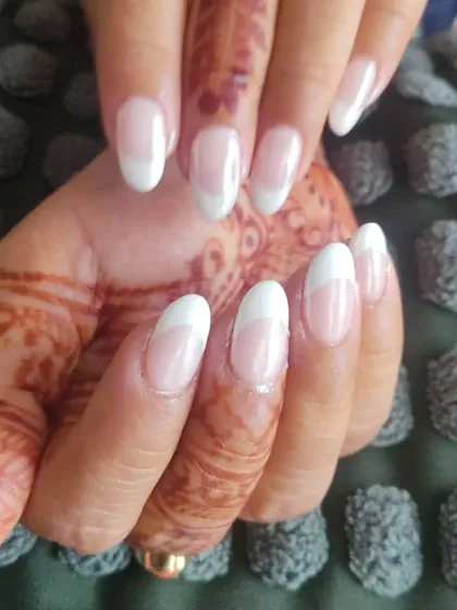 Here you can see how a classic French manicure on oval nails provides a perfect, clean backdrop for beautiful bridal mehendi.