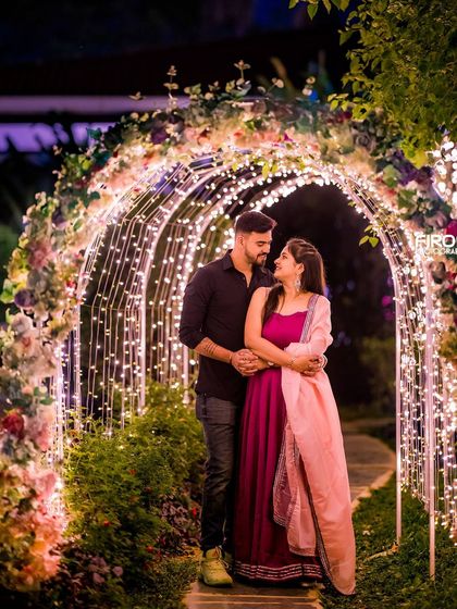 A romantic pose in the floral and light archway, a classic choice for a beautiful pre-wedding photo.