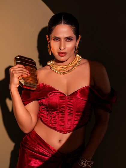 A confident and direct pose from the red velvet shoot. The strong lighting and direct gaze make this a compelling shot, perfect for showcasing a bold fashion statement.