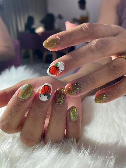 Spooky but make it glam. For Halloween, I created this fun set with glittery olive green polish and accent nails featuring hand-painted pumpkins.