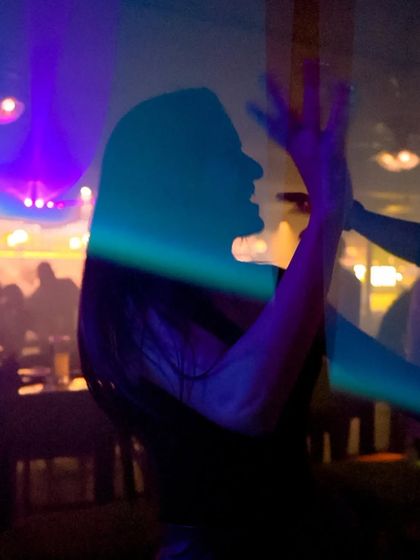 A beautiful silhouette of someone dancing, captured against the club's laser lights.