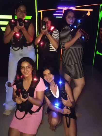 A duplicate of image 109, showing the girls geared up for laser tag.