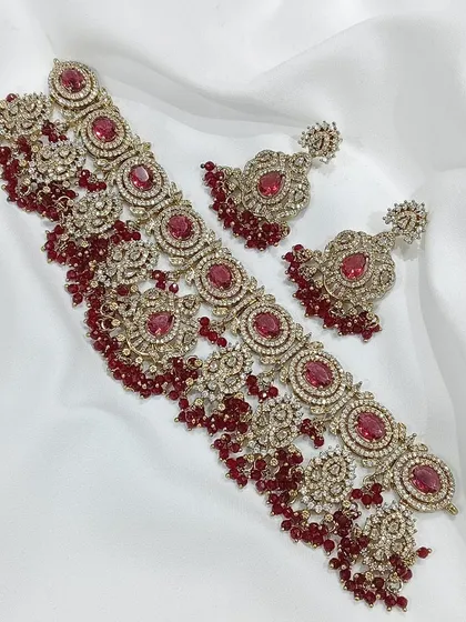 A stunning choker set with deep red stones and intricate filigree work, perfect for a bride.