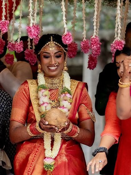 The bride's radiant smile as she makes her entrance, holding a sacred coconut, ready to begin her wedding ceremony.