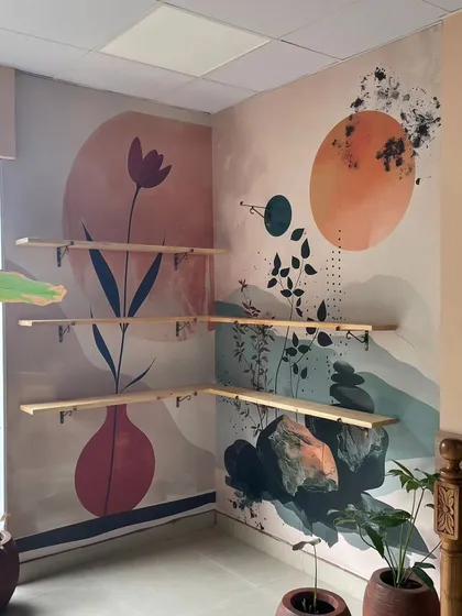 This abstract mural uses soothing colors and simple shapes like vases and botanicals. It was installed on a corner wall, creating a continuous piece of modern art that enhances the space.