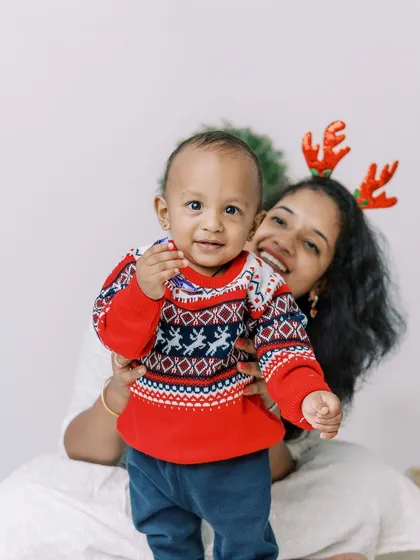 A mother and son sharing a happy moment during their Christmas shoot, complete with reindeer antlers.