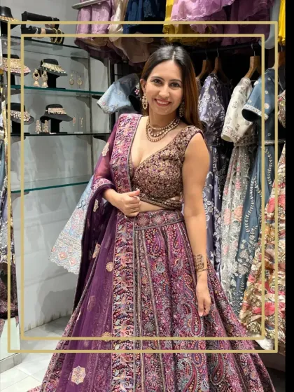A client looking fabulous in a rich purple lehenga with intricate paisley embroidery. This photo was taken in my store, showing how you can try on these amazing outfits.