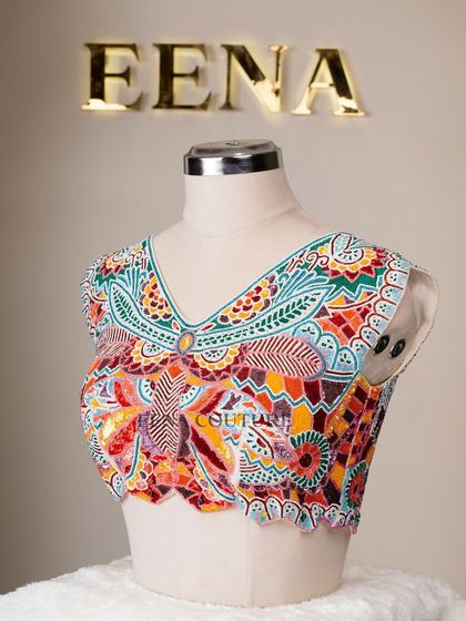 I designed this unique 'Butterfly Garden' blouse for the bride who loves color and artistry. The entire piece is covered in a vibrant mosaic of multi-colored beads and sequins, forming a stunning butterfly motif across the back.
