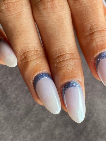 A close-up showing the detail of the glittery blue arch against the iridescent white base.