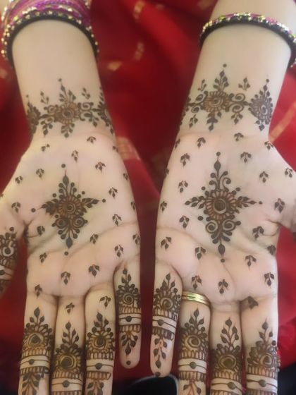 The front view of the minimal bangle-length design. The central star-like motif on the palm is simple yet captivating.