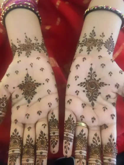 The front view of the minimal bangle-length design. The central star-like motif on the palm is simple yet captivating.