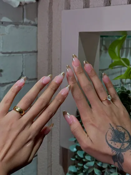 A classy twist on the classic French manicure. We used a beautiful gold chrome to create a luxurious and modern tipped look.