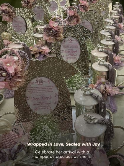 An overhead view of multiple baby announcement hampers prepared for a celebration. This image highlights the consistency and attention to detail across a large order, with each hamper featuring silver-plated items and lavender floral accents.