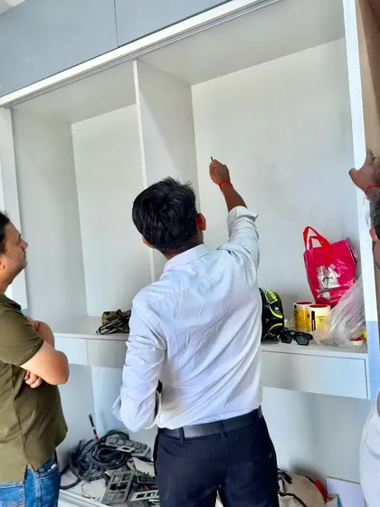 On-site, marking the precise points for fittings inside a custom wardrobe unit during its construction.