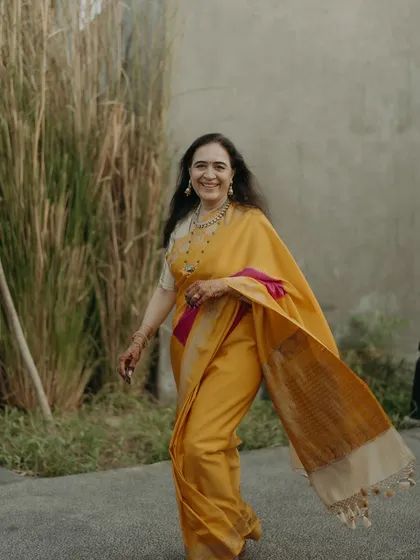 The mother of the bride in a radiant yellow saree, captured in a moment of pure joy. We believe in styling mothers in colors and textiles that make them feel confident and beautiful.
