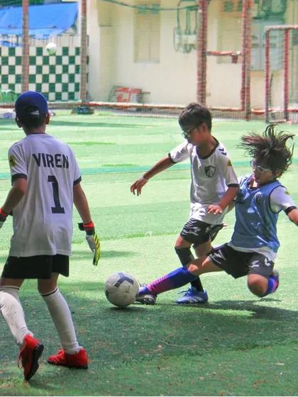 Intense on-field action during a youth match, where a player executes a perfectly timed slide tackle to win possession.