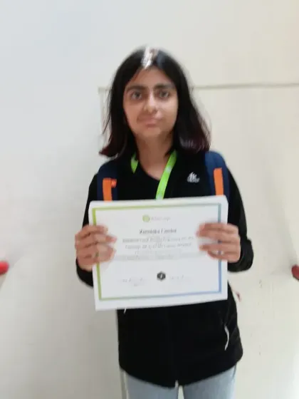 Our 7th-grade student holding her certificate of completion from the VEX Robotics summer camp at MIT. This represents a significant achievement and a valuable addition to her learning journey.