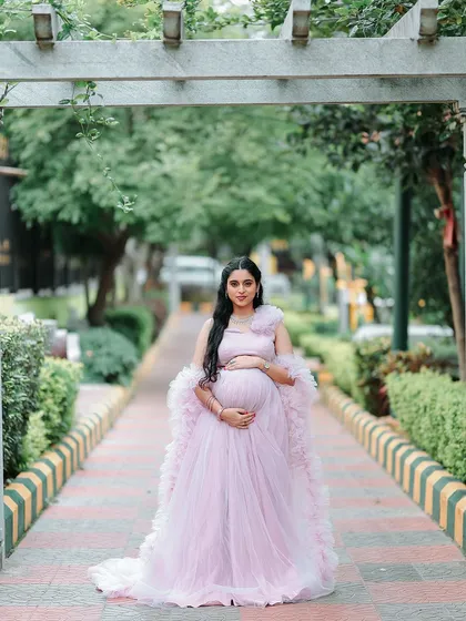 Capturing the beautiful glow of pregnancy is an honor. This client is wearing a custom-designed lavender ruffled gown for her maternity shoot, featuring a long, flowing trail that adds a touch of dreaminess.