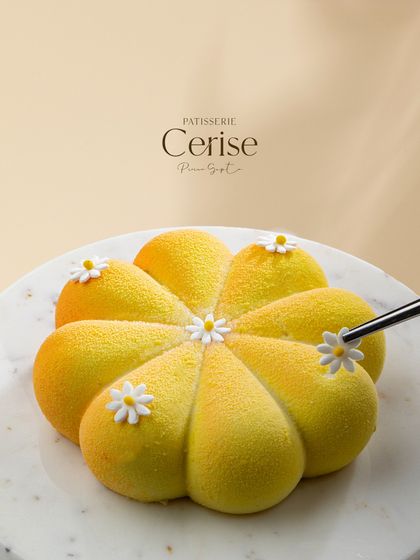 This is not your usual mango entremet. Shaped like a flower and finished with a yellow velvet spray, it's a warm, sweet, and sultry creation.