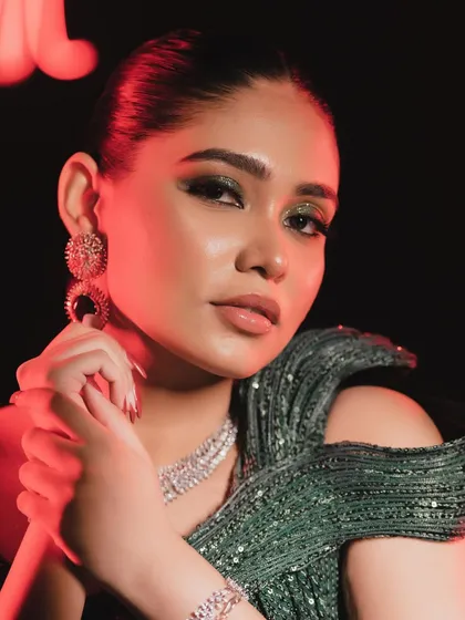 The red lighting adds a dramatic flair, but the makeup still shines through. The skin looks flawless and the eyes are mesmerizing.