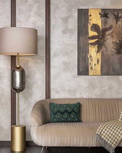 A quiet seating area within a bedroom, featuring a plush loveseat and elegant floor lamp. These thoughtful details create functional, comfortable zones within a larger space.