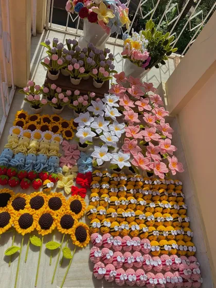 A beautiful flat lay of a large order, including amigurumi bees, jellyfish, strawberries, and bow keychains.