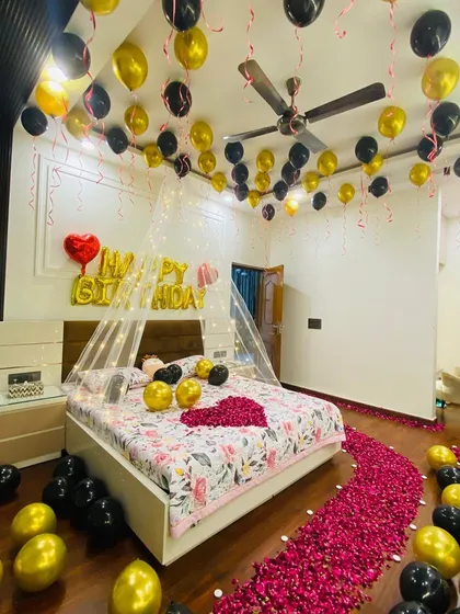 The complete birthday room surprise setup. This package includes ceiling balloons, a bed canopy, a rose petal path, and a heart made of petals on the bed, ensuring a memorable surprise.