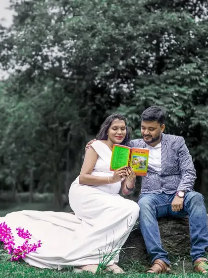 A themed maternity shoot can be a wonderful way to tell your story. Here, the couple shares a quiet moment reading a book together, creating a peaceful and intimate portrait in a natural setting.