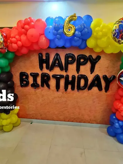 A straight-on view of the Avengers birthday balloon arch, showing the placement of the 'Happy Birthday' letter balloons and character foils.