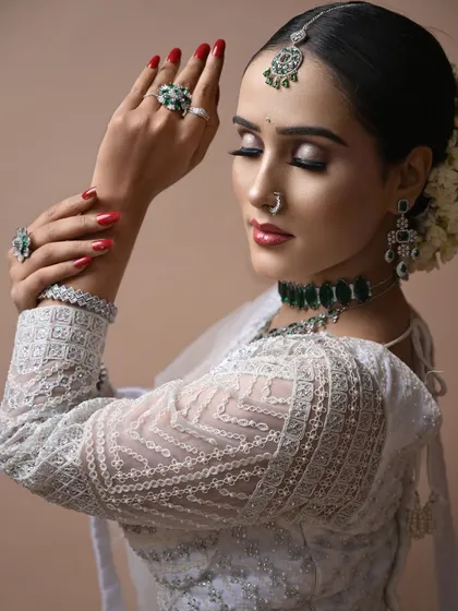 This angle shows the delicate details of the blouse and the smooth, clean lines of the hairstyle, complemented by the airbrush makeup.