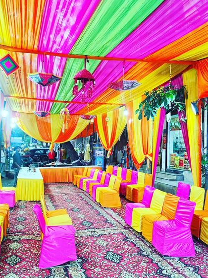 Another view of the bustling Mehendi tent, showcasing the vibrant atmosphere created with bright colours and lighting.