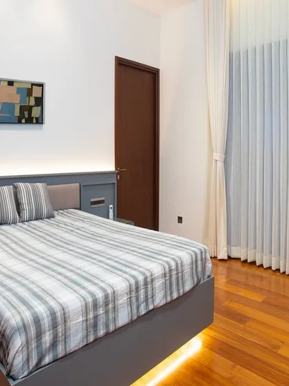 Simple design can make a big impact. The under-bed lighting gives the bed a floating effect, while the warm wood floors and calm grey headboard create a modern, relaxing mood.