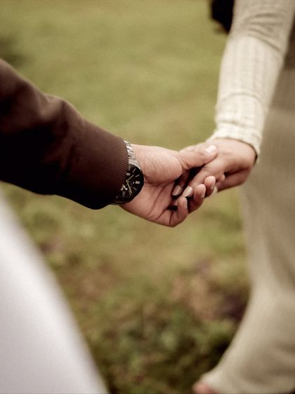 A close-up on the simple, powerful gesture of holding hands. This shot symbolizes their partnership and support for each other on this incredible journey.