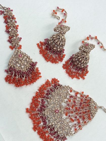A lovely two-toned mehndi set in shades of red and orange. The beadwork is intricate and perfect for a festive occasion.