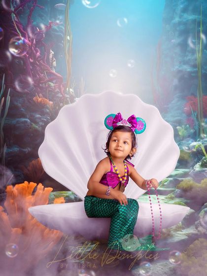 A little mermaid sitting on her seashell throne. This underwater fantasy theme is created with a beautiful backdrop and creative editing.