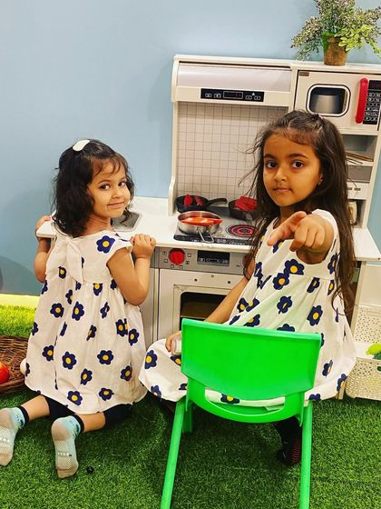 "I'm talking to you!" These sisters are having a blast role-playing in our fully stocked pretend kitchen.